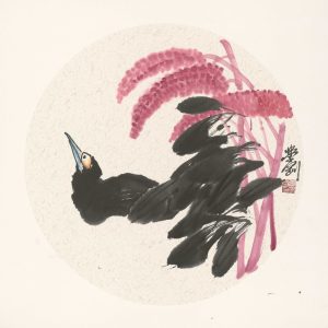 black bird looking up at pink flowers